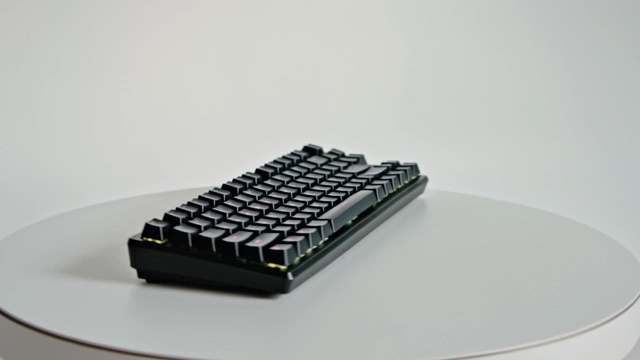 AI generated video: A minimalist black matte mechanical keyboard on a pure white infinite studio background, rotating smoothly 360 degrees, RGB lighting gently breathing, commercial product photography, soft high-key lighting, 4K cinematic grade